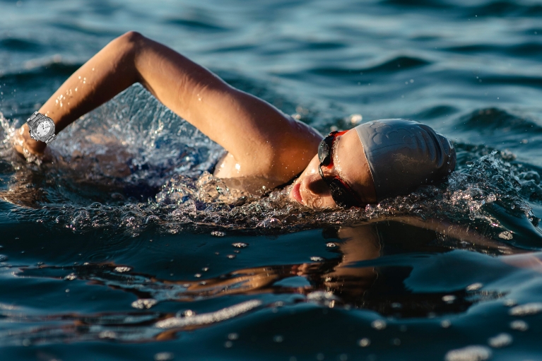 side-view-female-swimmer-with-cap-goggles-swimming-water-1