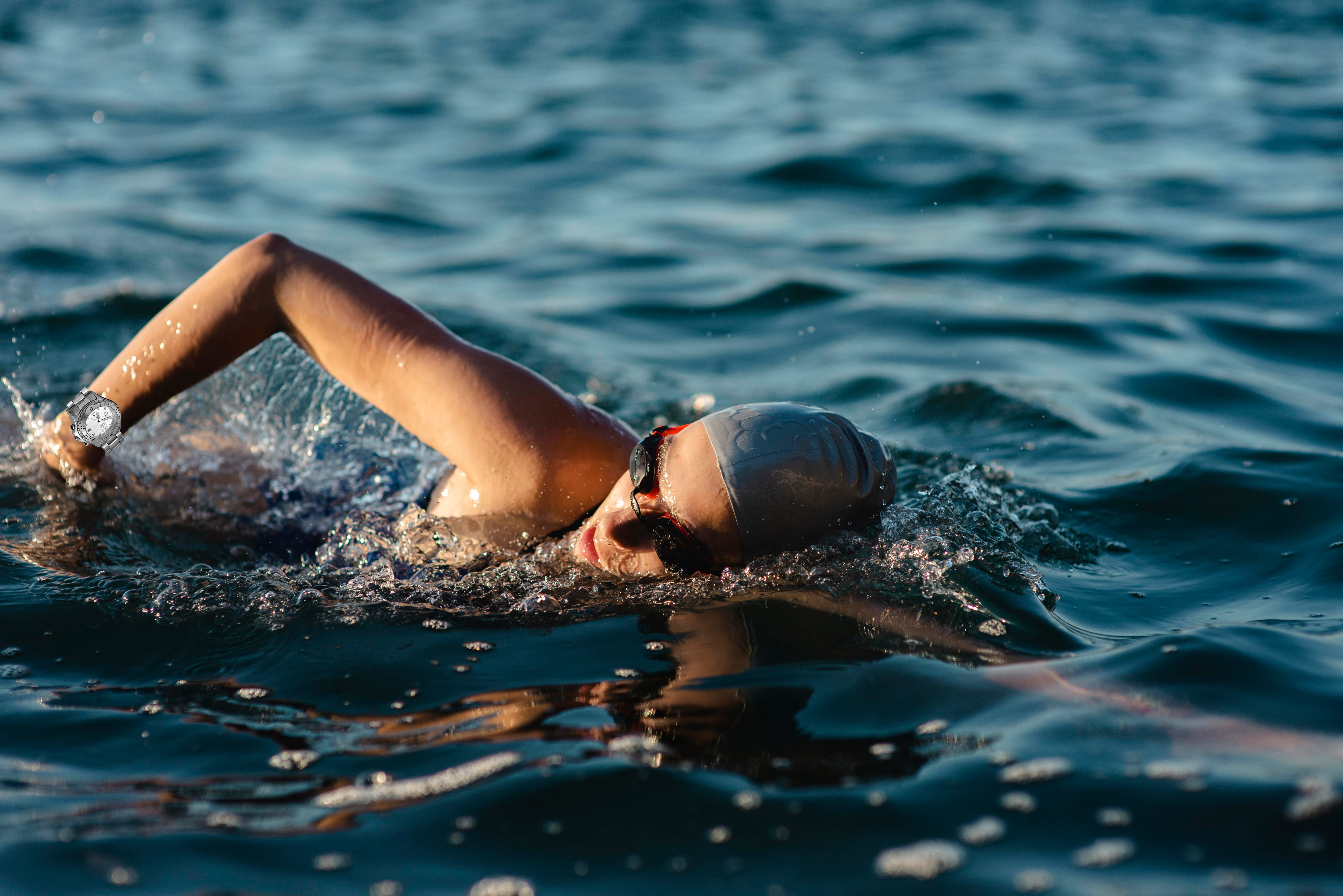 side-view-female-swimmer-with-cap-goggles-swimming-water-1